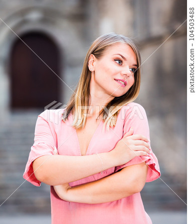 Close up of young positive female standing in the historical city center Close up of young positive female standing in the historical city center 104503488