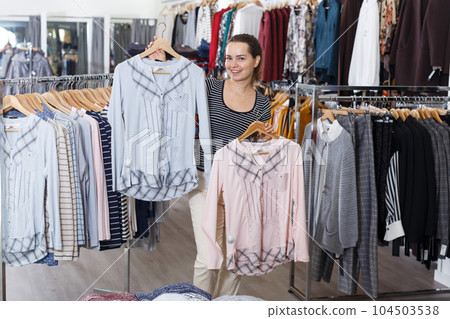 Woman choosing new clothes in showroom Woman choosing new clothes in showroom 104503538