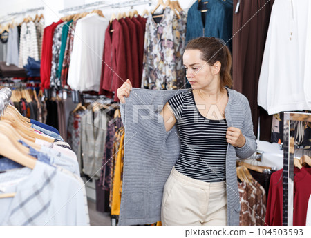 Woman trying blouse clothing boutique 104503593