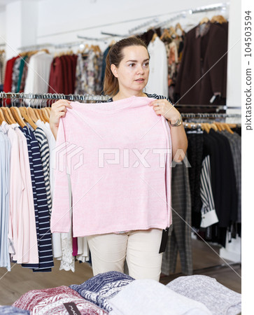 Woman choosing new clothes in shop 104503594