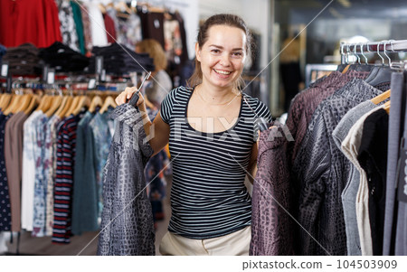 Woman choosing new overcoat in store Woman choosing new overcoat in store 104503909