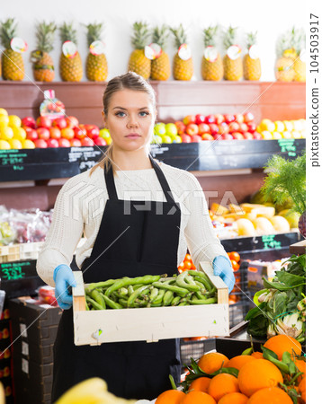 Salesgirl offering green beans 104503917