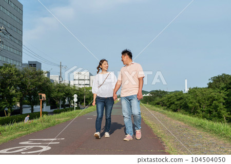 A couple walking hand in hand 104504050