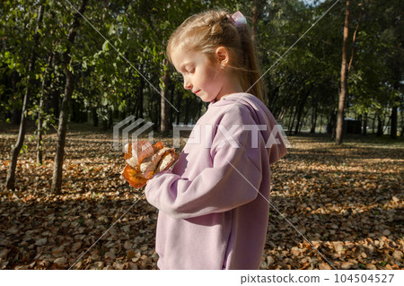 Joyful pretty young happy blond girl with a bouquet of autumn leaves poses in park. Cheerful girl likes to walk outdoors. Fall season. Great weekend. Joyful pretty young happy blond girl with a bouquet of autumn leaves poses in park. Cheerful girl likes to walk outdoors. Fall season. Great weekend. 104504527