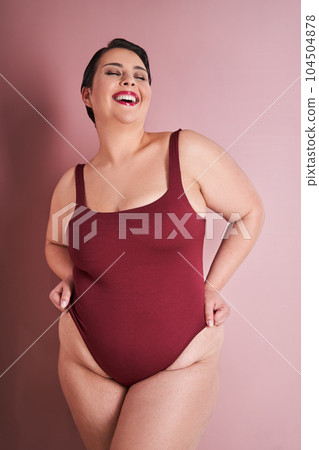Happy chubby korean woman laughing at red studio background 104504878