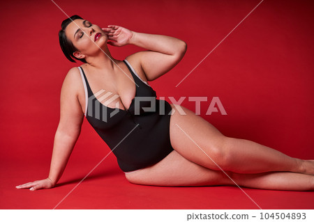 Full length view of the beautiful plump woman in black body posing with closed eyes Full length view of the beautiful plump woman in black body posing with closed eyes 104504893