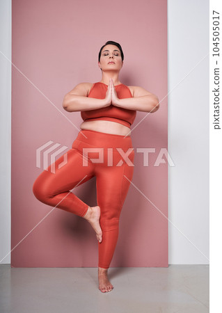 Vertical view of the body positive woman training yoga, meditating with connected hands Vertical view of the body positive woman training yoga, meditating with connected hands 104505017