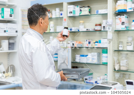 Pharmacist working in a dispensing room of a pharmacy, hospital, drug store (prescription, medicine, supplement) Pharmacist working in a dispensing room of a pharmacy, hospital, drug store (prescription, medicine, supplement) 104505024