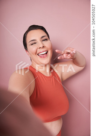 Vertical view of the attractive overweight female having delightful look smiling broadly 104505027