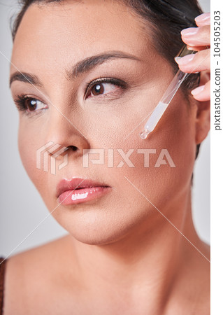 Vertical studio shot of natural woman in underwear with beauty serum promoting body positivity 104505203