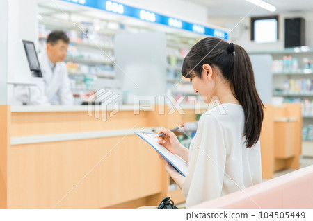 一名婦女在醫院/藥房的候診室填寫醫療調查問卷 104505449