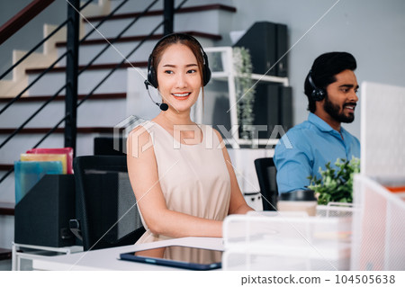 Customer service operator with headsets working at call centre 104505638