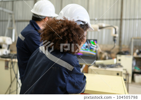 Engineer technician controlling robotic arms on computer laptop 104505798