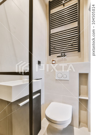 a modern bathroom with black and white tiles on the walls, toilet, sink, and towel rack in it a modern bathroom with black and white tiles on the walls, toilet, sink, and towel rack in it 104505814