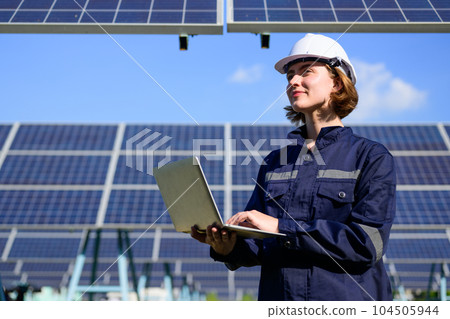 Engineer worker portrait with solar panel at solar farm 104505944