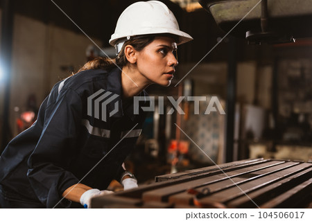 Confident female technician engineer worker checking and inspecting machine 104506017