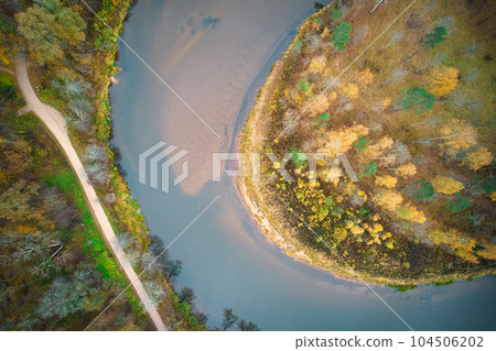 Above aerial shot of green pine forests and yellow foliage groves with beautiful texture of golden treetops. Beautiful fall season scenery in evening. Mountains in autumn colors in golden time 104506202