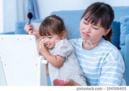 Mom doing makeup while raising a child 104506403