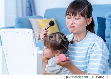 Mom doing makeup while raising a child 104506404