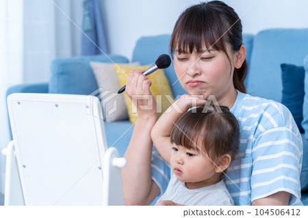 Mom doing makeup while raising a child 104506412