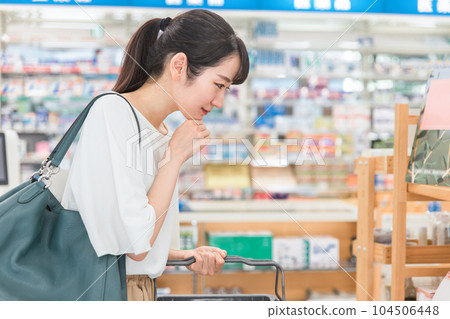 A woman shopping at a pharmacy, drug store, or convenience store 104506448