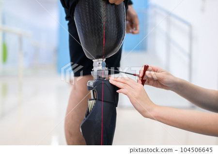 Physiotherapist adjusting prosthetic leg of patient in hospital Physiotherapist adjusting prosthetic leg of patient in hospital 104506645