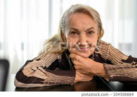 Smiling portrait of healthy senior woman smiling and sitting at home Smiling portrait of healthy senior woman smiling and sitting at home 104506664