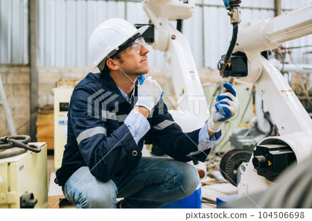 Engineer technician controlling robotic arms on computer laptop 104506698