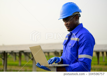 Engineer worker checking and maintaining solar panels on solar farm 104506757