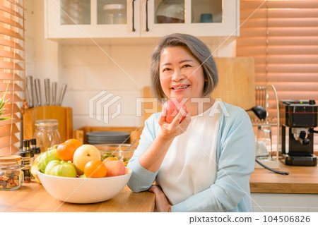 senior portrait. cheerful senior smiling portrait. mature woman eating fruit. 104506826