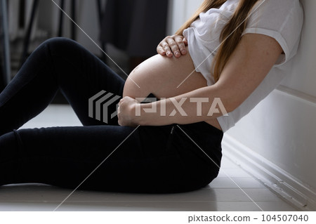 Close-up belly pregnant girl white top fingers hands folded heart stomach concept happy motherhood preparation for birth Close-up belly pregnant girl white top fingers hands folded heart stomach concept happy motherhood preparation for birth 104507040