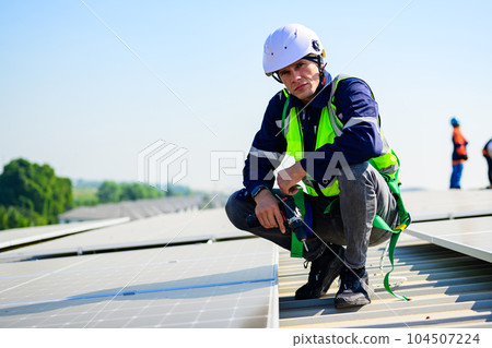 Professional engineer with safety helmet checking system at solar cell farm 104507224