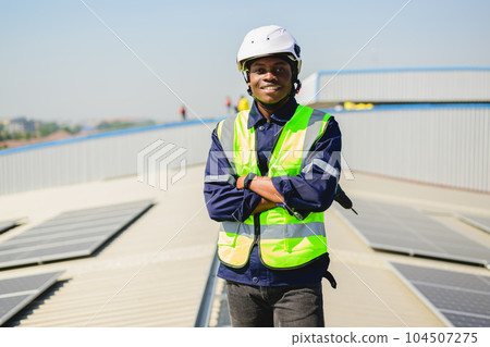 Engineers with safety helmet checking solar system at solar power farm 104507275