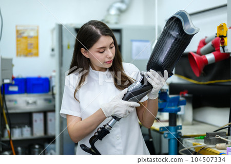 Prosthetic technician holding prosthetic leg checking and controlling 104507334