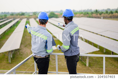 Maintenance engineer maintaining solar panels on solar cell farm Maintenance engineer maintaining solar panels on solar cell farm 104507403