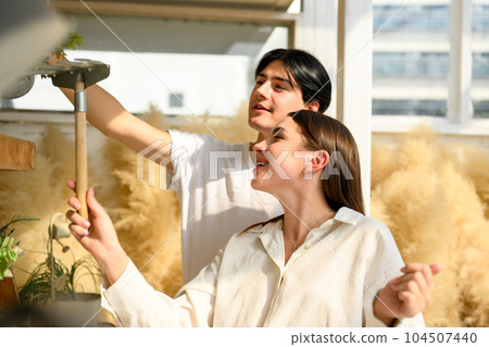 Couple of happy young people spending time together at home on weekend 104507440