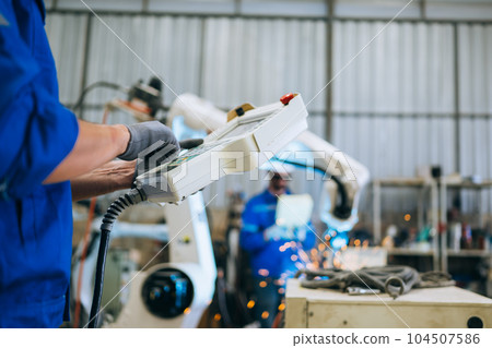 Engineer technician controlling robotic arms on computer laptop 104507586