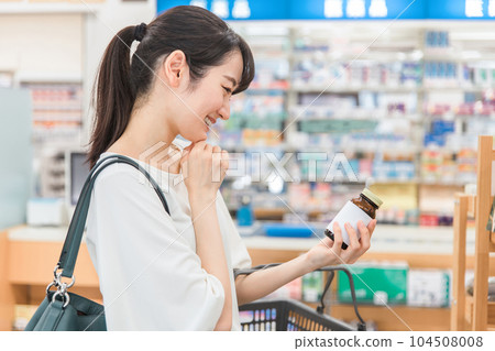A woman shopping at a pharmacy, drug store, or convenience store A woman shopping at a pharmacy, drug store, or convenience store 104508008