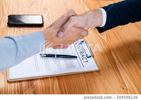 Two business people shake hand after successfully signing contract. Entity Two business people shake hand after successfully signing contract. Entity 104508126