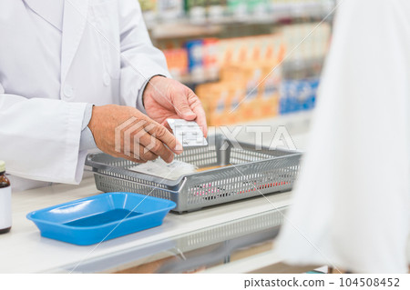 A woman and a pharmacist man consulting for medicine at a pharmacy A woman and a pharmacist man consulting for medicine at a pharmacy 104508452