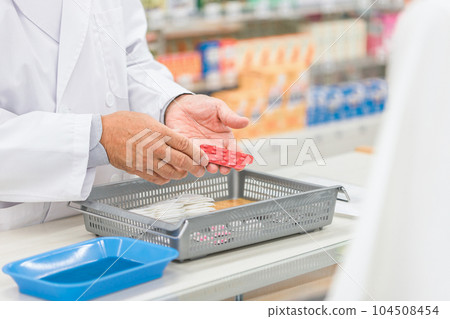 A woman and a pharmacist man consulting for medicine at a pharmacy A woman and a pharmacist man consulting for medicine at a pharmacy 104508454