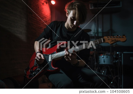 Male Caucasian teenager playing guitar in garage activity music. Generative AI AIG23. 104508605