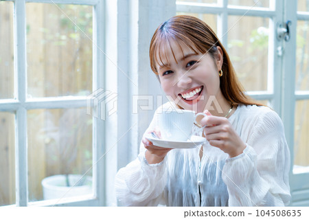 Generation Z woman drinking coffee by the window 104508635
