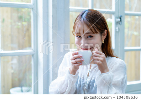 Generation Z woman drinking coffee by the window 104508636
