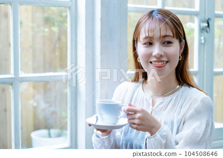 Generation Z woman drinking coffee by the window Generation Z woman drinking coffee by the window 104508646