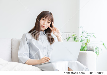 A woman watching a laptop computer in the room 104509098