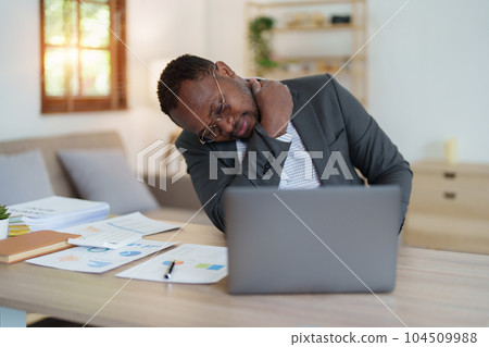 Burnout American African business man in stress works with many paperwork document, migraine attack, Freelance, work from home. Burnout American African business man in stress works with many paperwork document, migraine attack, Freelance, work from home. 104509988