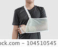 Young man with hand injured wearing splint, broken arm, isolated on white background 104510545
