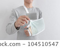 Young man with hand injured wearing splint, broken arm, showing empty blank card, isolated on white background 104510547
