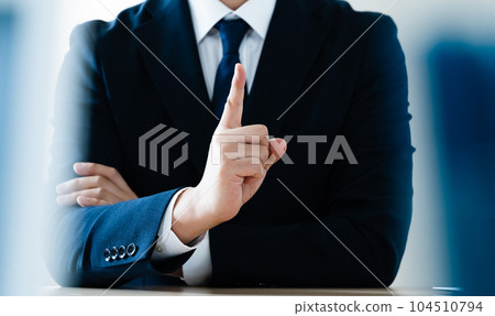 Businessman raising index finger 104510794